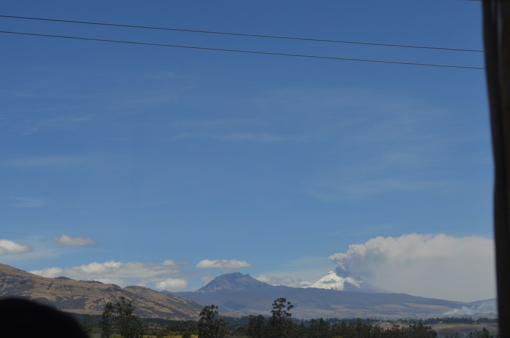 Cotopaxi from a bus window. Hard to see from this picture but the snow is melted on half of it (in the direction the smoke is blowing)